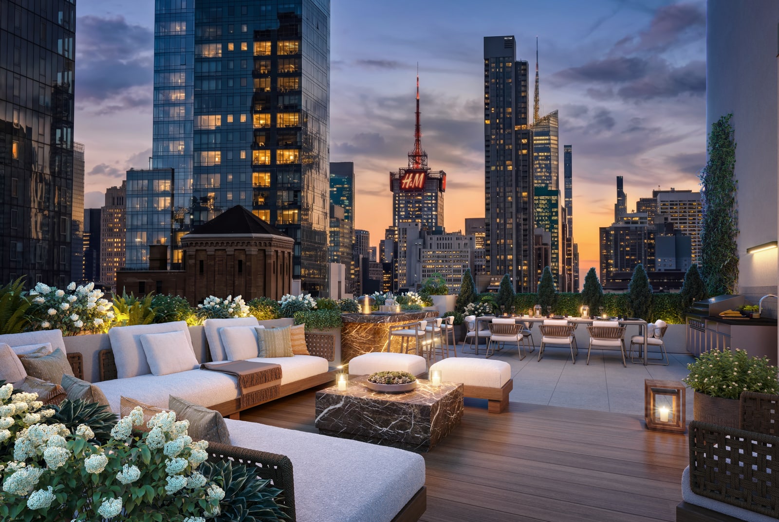 A landscaped rooftop terrace with lounge seating and sunset views over Manhattan